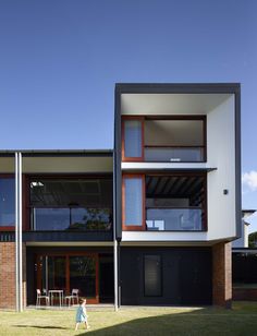 a person walking in front of a building with windows and balconies on it