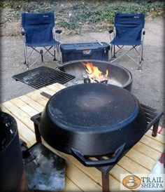 an outdoor grill with chairs around it