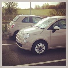 two cars parked in a parking lot next to each other