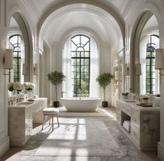 an elegant bathroom with arched windows and marble flooring, along with two sinks and tub