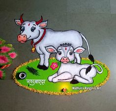 a cow and calf sitting on top of a green rug