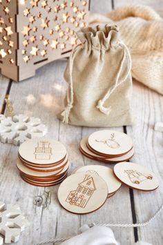 small wooden coasters are sitting on a table next to a bag and snowflakes