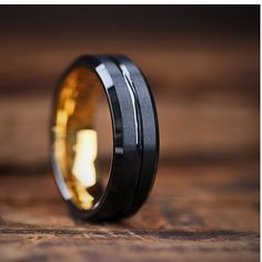 This ring combines modern black with classic yellow gold, bringing together two of the most popular colors. The exterior features two parallel stripes with a matte texture finish, while the center and tapered edges boast a black polish finish. Ring Engraving Available. Specifications Tungsten Carbide Exterior: Black Matte Exterior: Polished Center Channel Exterior: Polished Tapered Edges Interior: 18k Yellow Gold Plated 7mm Width Comfort-Fit High Scratch Resistance Ring Box Included Yellow Gold Wedding Rings, Black Tungsten Wedding Band, Ring Engraving, Gold Wedding Bands, Mens Gold Wedding Band, Tungsten Carbide Wedding Bands, Yellow Gold Wedding Ring, Black Tungsten, Tungsten Carbide Rings