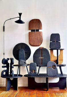 an assortment of chairs and lamps are arranged on the wall in front of each other