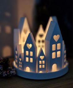 paper houses are lit up on a table