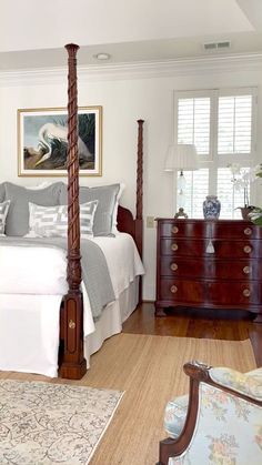 a bedroom with a four poster bed and dressers in it's center area