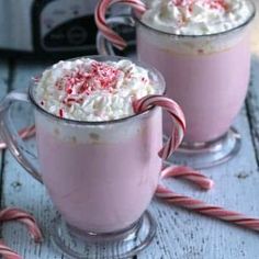 two glasses filled with hot chocolate and candy canes