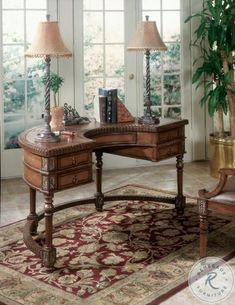 a desk with two lamps on top of it and a rug in front of it