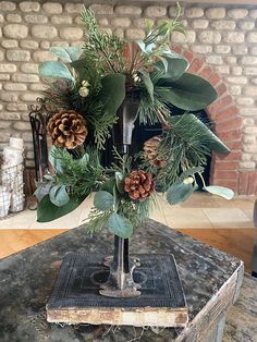 a vase filled with pine cones and greenery