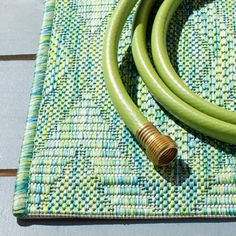 a green hose laying on top of a mat