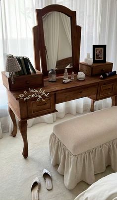 there is a dressing table with a mirror and shoes on the floor