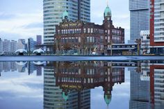 the buildings are reflected in the still water