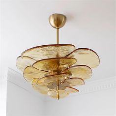 a golden chandelier hanging from the ceiling in a room with white walls and ceilings