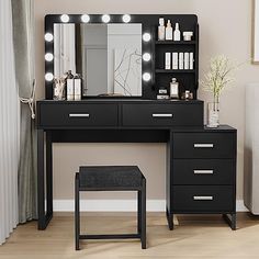 a black vanity with lights on it and a stool