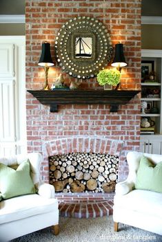 a living room filled with furniture and a fire place under a mirror on the wall