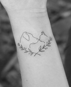 a black and white photo of a small wrist tattoo with a cat sleeping on it