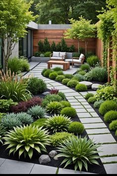 a very nice looking garden with lots of green plants and bushes in it, along with a bench