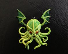 an octopus with red eyes is hanging on a black wall and it's head is made out of green plastic