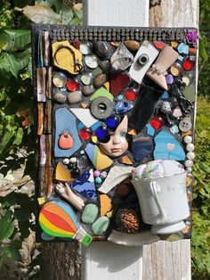 a piece of art that is on the side of a wooden pole with paint and other items