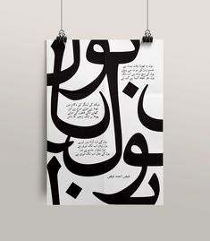 an arabic calligraphy poster hanging on the wall with two strings in front of it