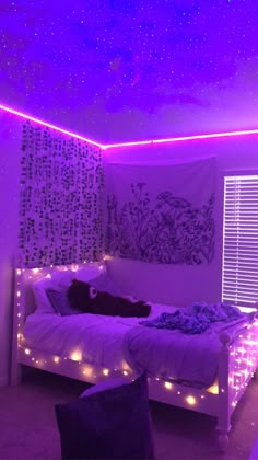 a bedroom with purple lights on the ceiling and a white bed in front of a window