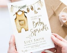 a person holding up a baby shower card