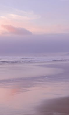 two people walking on the beach carrying surfboards