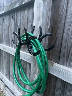 there is a green hose hanging on the fence