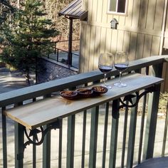 two glasses of wine are sitting on the balcony railing