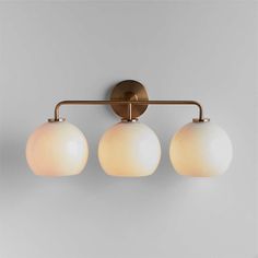 three light bathroom fixture in an antique brass finish with frosted glass globe shade shades