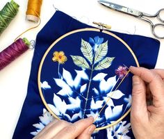 a person is working on a flower embroidery project