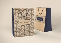 two paper bags with the name micelle on them, one in blue and one in beige