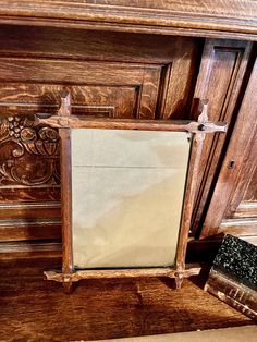 an old mirror is sitting on top of a wooden shelf