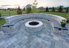 an outdoor fire pit surrounded by stone walls