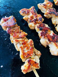 chicken skewers are being cooked on a grill