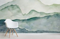 a white chair sitting in front of a wall mural