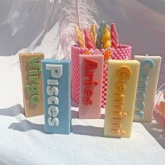 three candles with words on them sitting in front of a snow covered mountain and sky