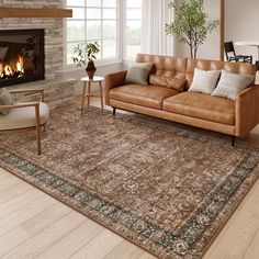 a living room with a couch, chair and fire place in front of a window