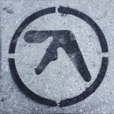 a black and white circle with the letter t in it's center on concrete