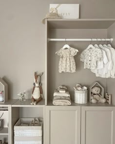 a baby's room with clothes and toys on the shelves in front of it