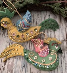 three ornaments are hanging on a wooden surface