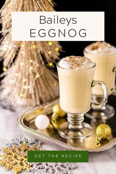 two glasses of eggnog on a tray with christmas decorations