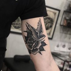 a person with a tattoo on their arm that has a bird and flowers on it