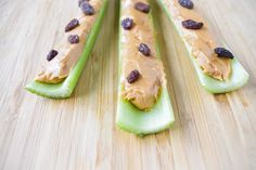 two pieces of celery with peanut butter and raisins on them