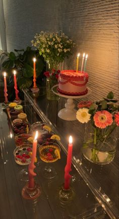 a table topped with lots of cakes and candles