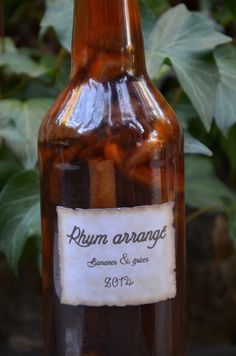 a brown bottle filled with lots of food on top of a wooden table next to green leaves