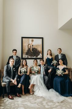 a group of people sitting next to each other in front of a painting on the wall