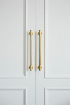 two white doors with gold handles in a room