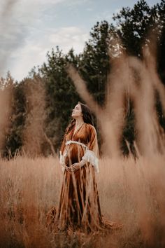 a woman is standing in the middle of a field with her eyes closed and looking up