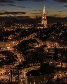 an aerial view of a city at night with the lights on and buildings lit up